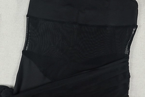 Detail view of black bodycon dress showing sheer mesh stitching and fabric texture