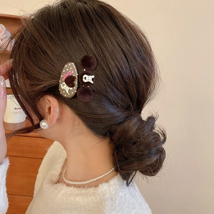 Close-up of brown velvet hair clips with polka dots and cartoon bunny on model hairstyle