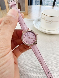 Detail of pink croc-texture leather strap and diamond bezel on a lady's quartz watch