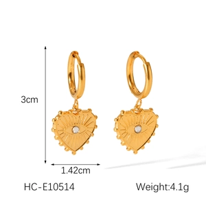 Detail shot of heart earrings with evil eye design and white zircon in gold finish