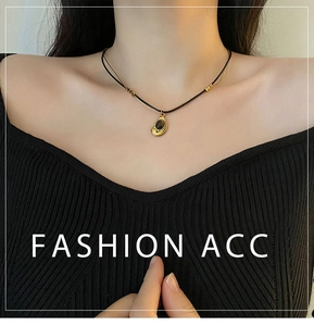 Close-up of vintage double-layer necklace featuring black oval stone in gold frame