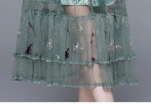 Detail of green mesh dress featuring exquisite flower embroidery and dot texture