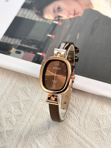 Detail of vintage oval watch with brown leather strap and rose gold Roman dial