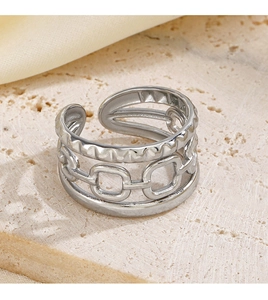 Dettaglio dell'anello d'argento a tre strati su sfondo di pietra beige chiaro