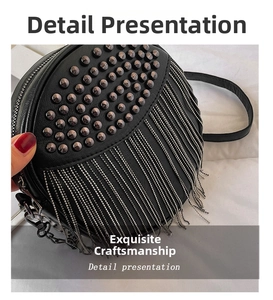 Detail view of round black crossbody bag with bronze studs and silver chain tassels