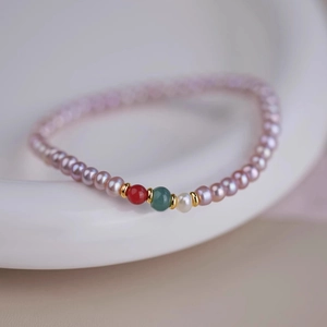 Macro detail of natural lavender pearls and colorful agate beads on the handmade bracelet