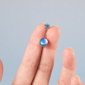 Detailed close-up of curved stainless steel belly ring with vibrant blue-green gemstones
