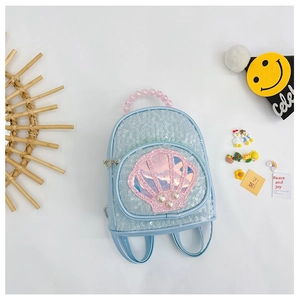 Detail of blue sequin shell backpack featuring pearl accents and pink beaded handle