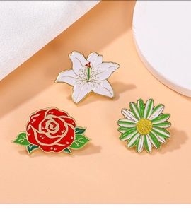 Set of three floral enamel pins including lily, rose, and daisy with polished gold finish