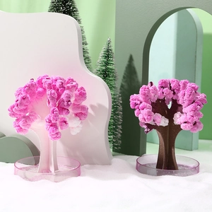 Magic paper Christmas tree with pink crystal blooming on a white base plate