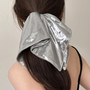 Metallic silver scrunchie with liquid metal texture on a high ponytail hairstyle
