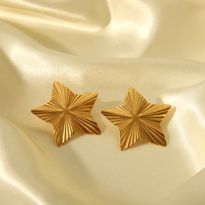 Fashionable gold stainless steel star stud earrings with radial texture on champagne silk