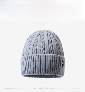 Detailed cable knit texture and ribbed cuff on a light grey winter beanie hat