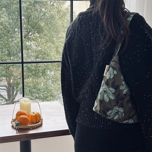 Dettaglio della borsa a tracolla jacquard floreale verde scuro in stile lifestyle