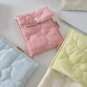 Close-up of cloud quilting pattern on pastel pink, blue, and yellow sanitary pad pouches