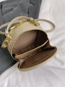 Beige embroidered ethnic style round crossbody bag with golden hardware and interior view