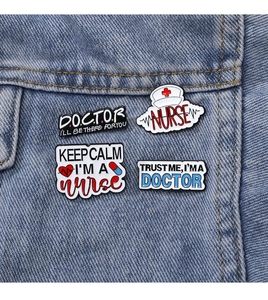 Détail de quatre épinglettes médicales en émail avec slogans pour médecins sur veste en jean