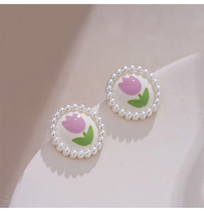 Macro detail of tulip clip earrings with vintage painted petals and white pearl border