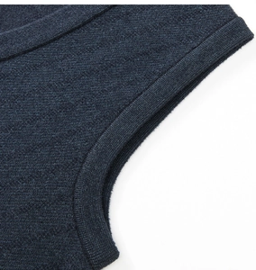 Detailansicht einer dunkelblauen Strickweste mit geripptem Armausschnitt und Struktur