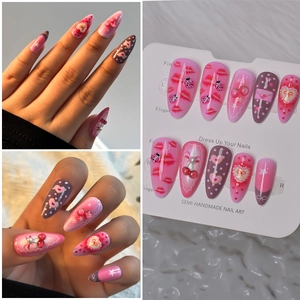 Detailed view of handmade almond press-on nails with 3D cherry and red lip designs