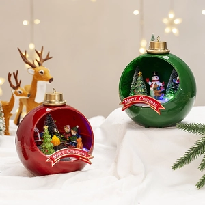 Detail showing glowing Christmas snow house globes with festive miniature scenes and LED light