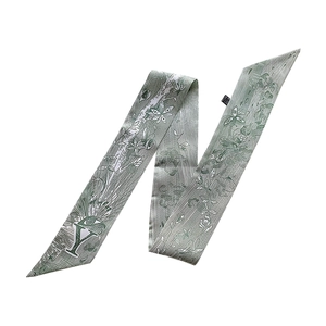Detail of grey-green silk scarf with vintage eye pattern and printed letter Y design