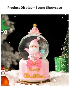 Detailed pink Christmas snow globe music box with resin Santa figurine on artificial snow