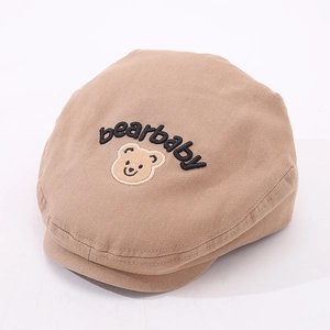Detailed close-up of bearbaby embroidery on beige cotton baby beret cap for toddlers