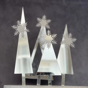 Detail view of silver mirror acrylic Christmas tree cake toppers with snowflake design