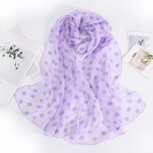 Dettaglio macro dello scialle in chiffon viola a pois con texture morbida e leggera