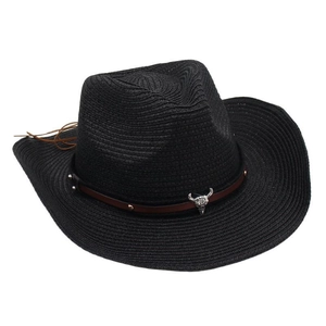 Detail of black straw cowboy hat featuring brown leather band and silver bull skull ornament