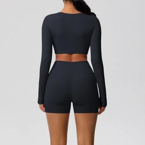 Achteraanzicht van een nauwsluitende zwarte crop top met lange mouwen en fitness short