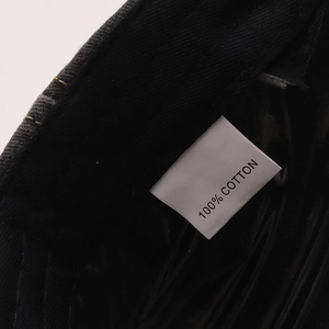 Close-up of internal fabric label showing 100% cotton material on washed denim cap