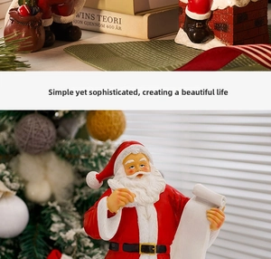 Close-up of resin Santa Claus figurine writing a list with festive Christmas decor