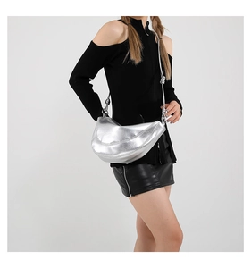 Close-up of metallic silver crescent bag with textured faux leather and slim shoulder strap