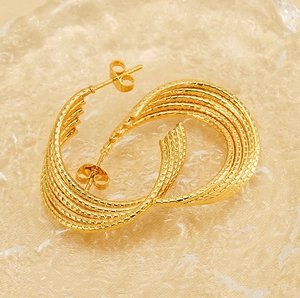 Detailed close-up of 18k gold plated U-shaped earrings with twisted textured design