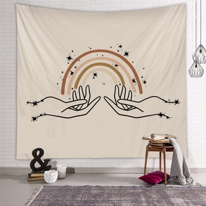 Detail of bohemian tapestry with sun and stars hanging on a white brick wall in room