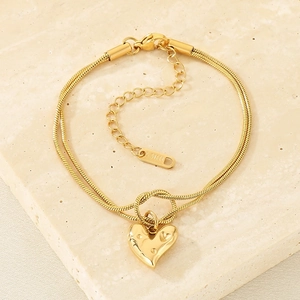 Detail of gold double-layer snake chain bracelet with heart pendant and lobster clasp
