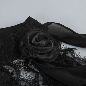 Detailed close-up of intricate black lace fabric with decorative satin rose embellishment