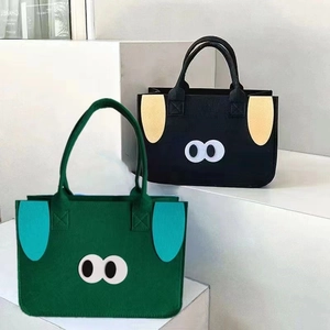 Cute felt tote bags with cartoon eyes in green and black colors for shopping or travel
