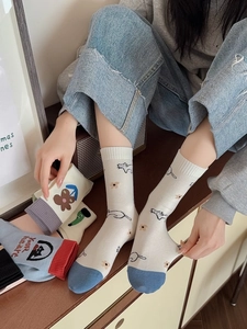 Detail of five pairs of cotton crew socks with cartoon dog patterns and floral designs