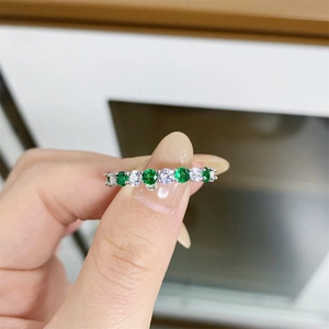 S925 sterling silver ring with alternating green and clear stones on finger
