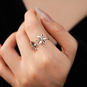 Close-up of vintage hollow flower open ring in silver finish on a model's hand