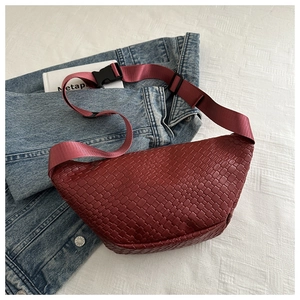Macro shot of dark red woven texture waist bag with adjustable strap and buckle