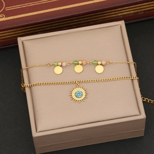 Detail of layered gold necklace with star pendant and colorful crystal beads