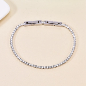 Detailed close-up of a silver tennis bracelet featuring sparkling zircon stones and double clasp