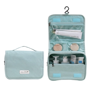 Detail of light blue hanging toiletry bag with multiple compartments and a metal hook