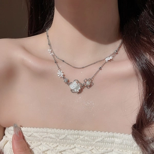Detail of silver double-layer necklace with white flowers, daisies and elegant pearls