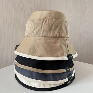 Vertical stack of multi-color cotton bucket hats showing side label details