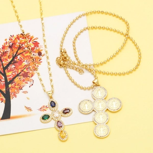 Detail of golden cross necklace with colorful zircons and religious icon medals